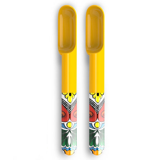 Two yellow plastic spoons with colorful patterns on a white background