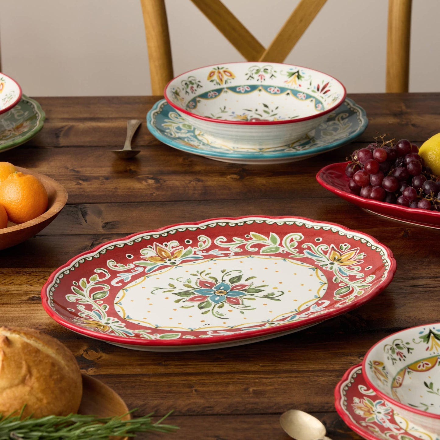 Decorative ceramic platters and bowls 
with floral patterns on a wooden table.
