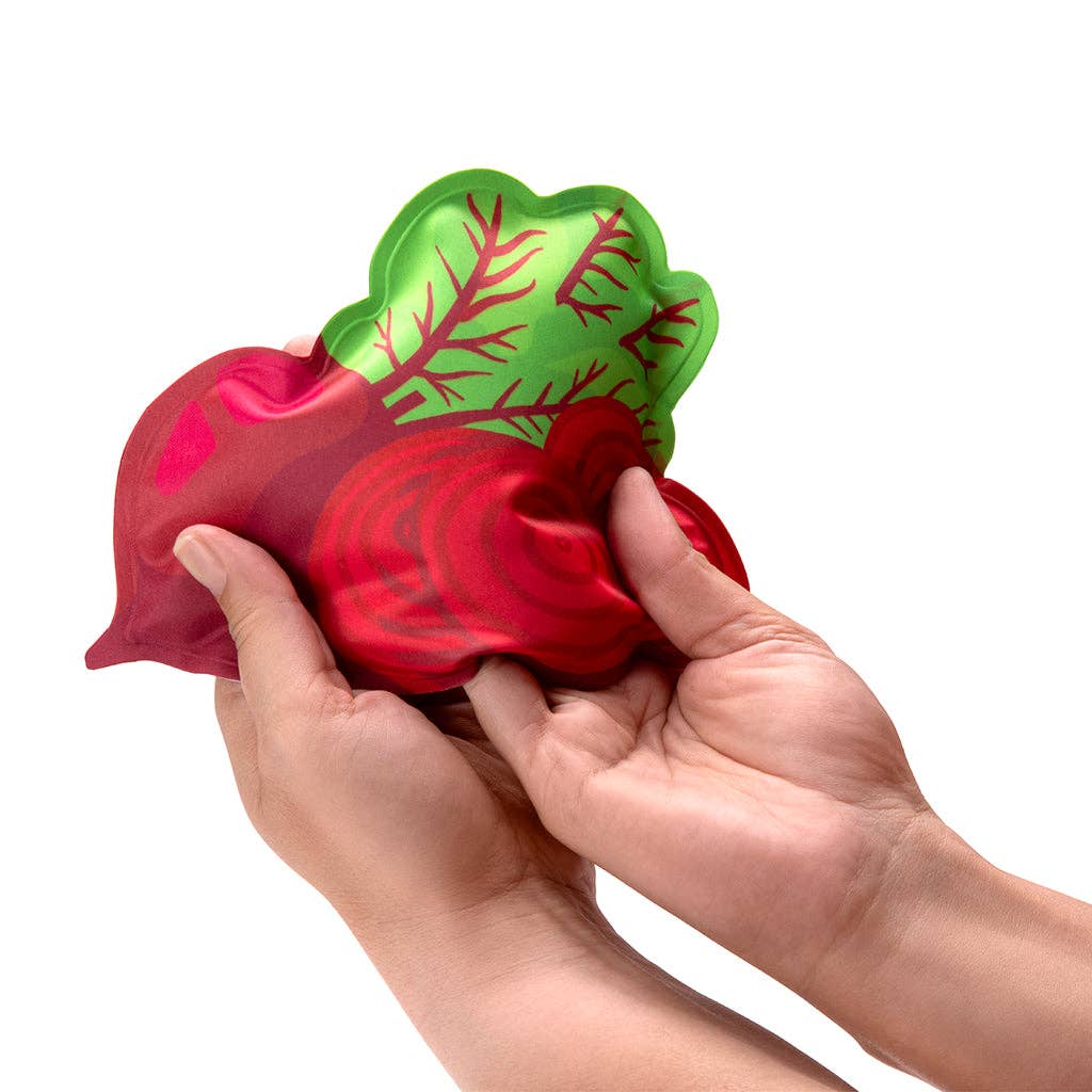 Hand holding a red and green radish shaped ice pack on a white background