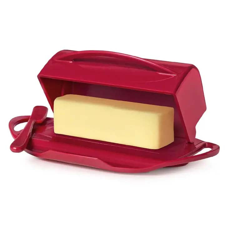 Red butter dish with a stick of butter and a knife on a white background