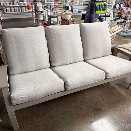 Gray outdoor sofa with cushions in a store setting