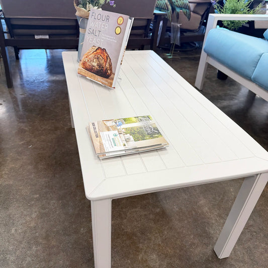 White table with books on a concrete floor in an indoor setting