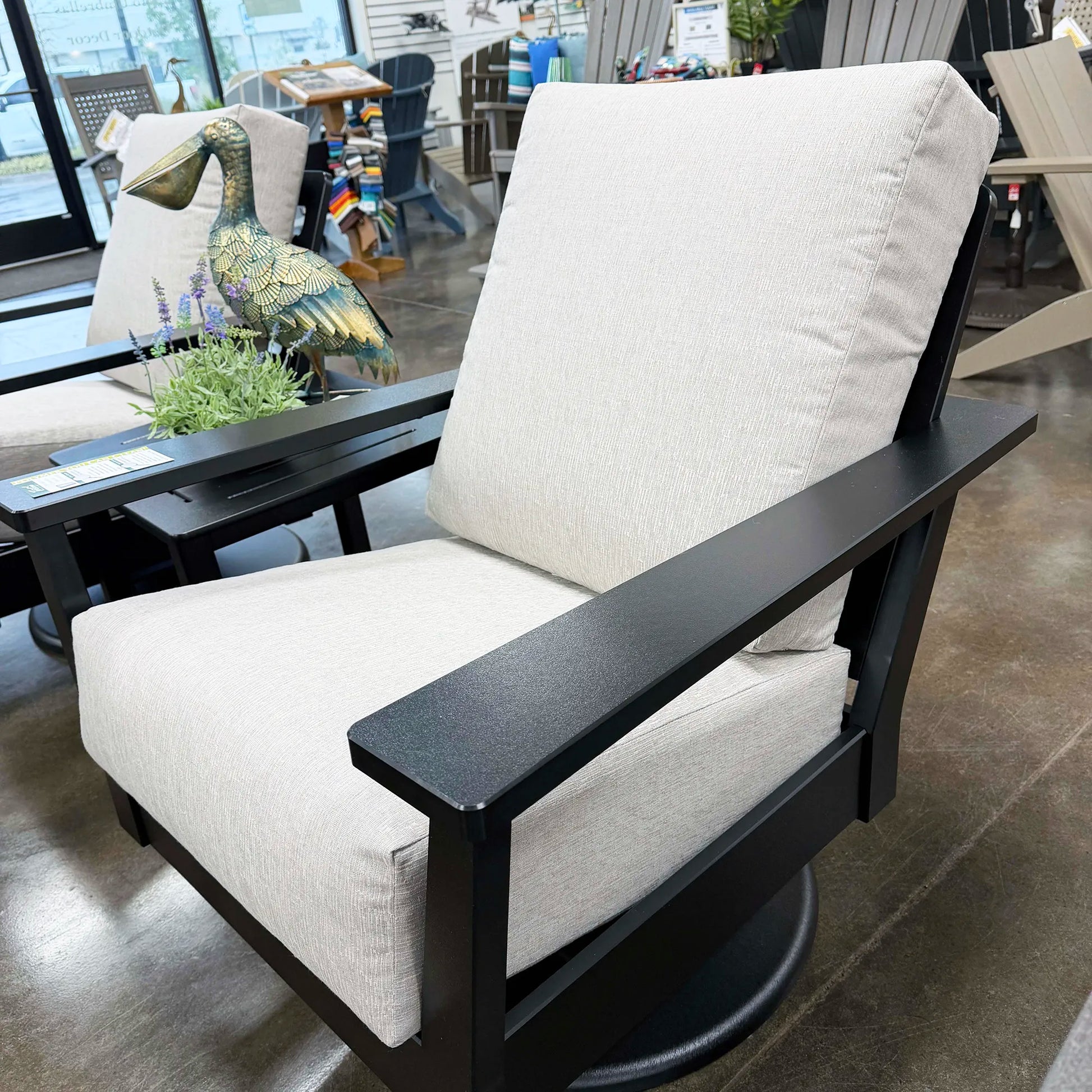 White cushioned chair with black frame in a store setting