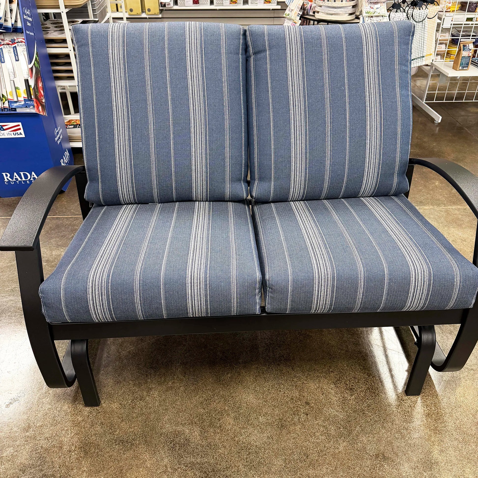 Blue striped outdoor loveseat in a store setting