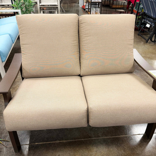 Beige two-seater sofa in an indoor setting with a blurred background