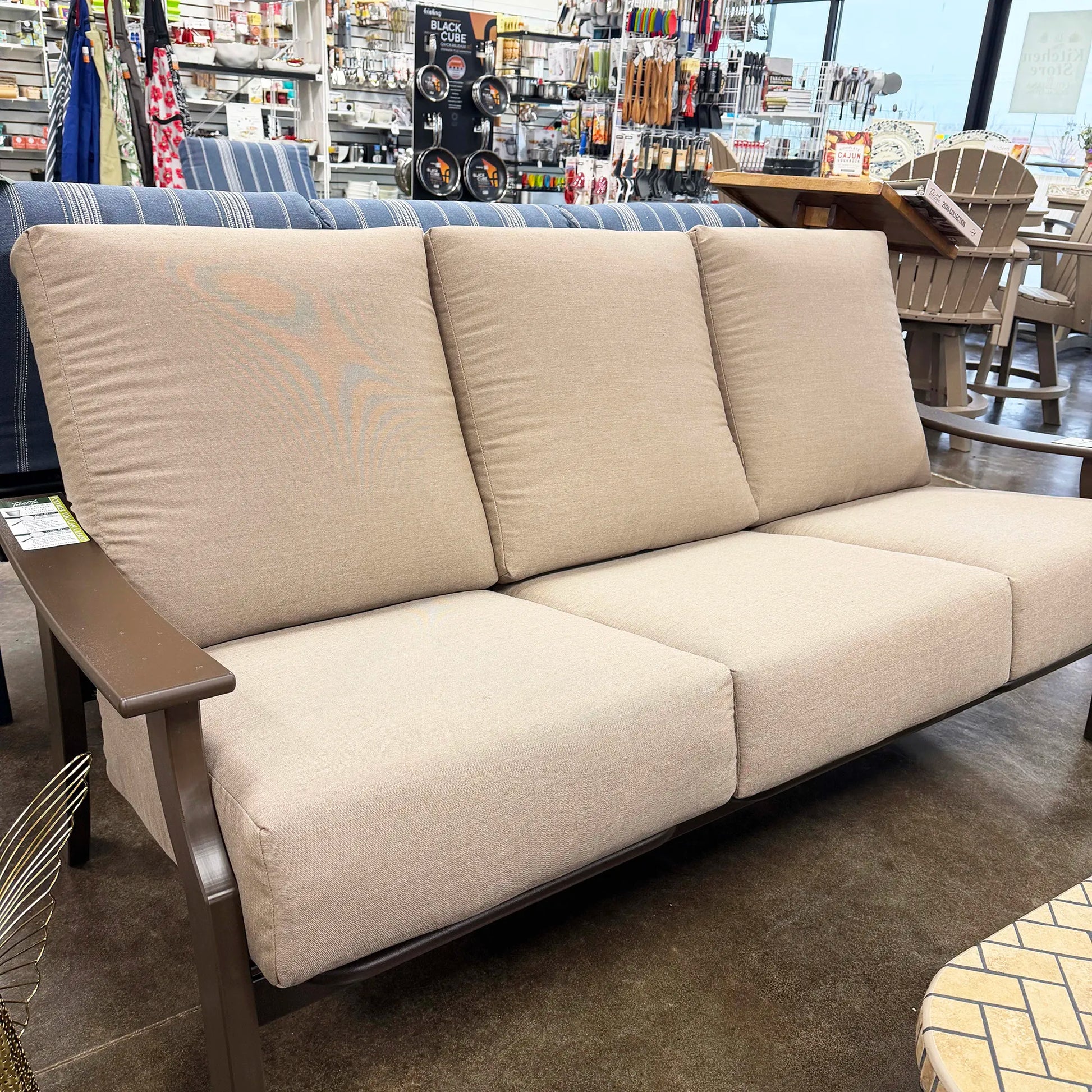 Beige sofa in a store setting with various products in the background
