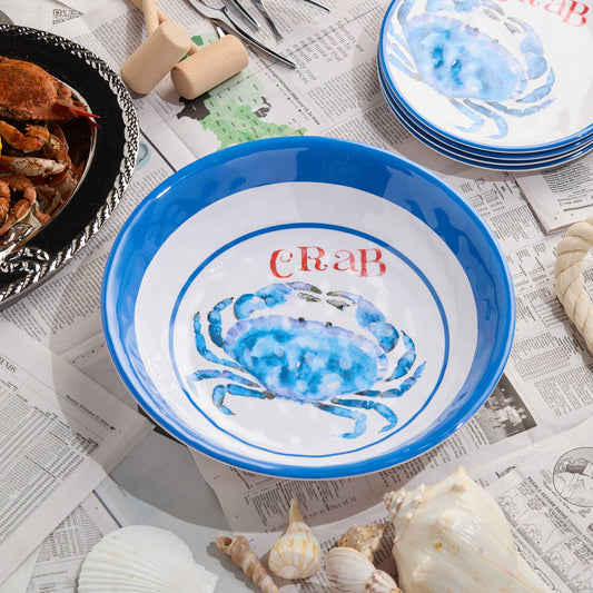 Blue crab-themed bowl on a table with newspaper and shells