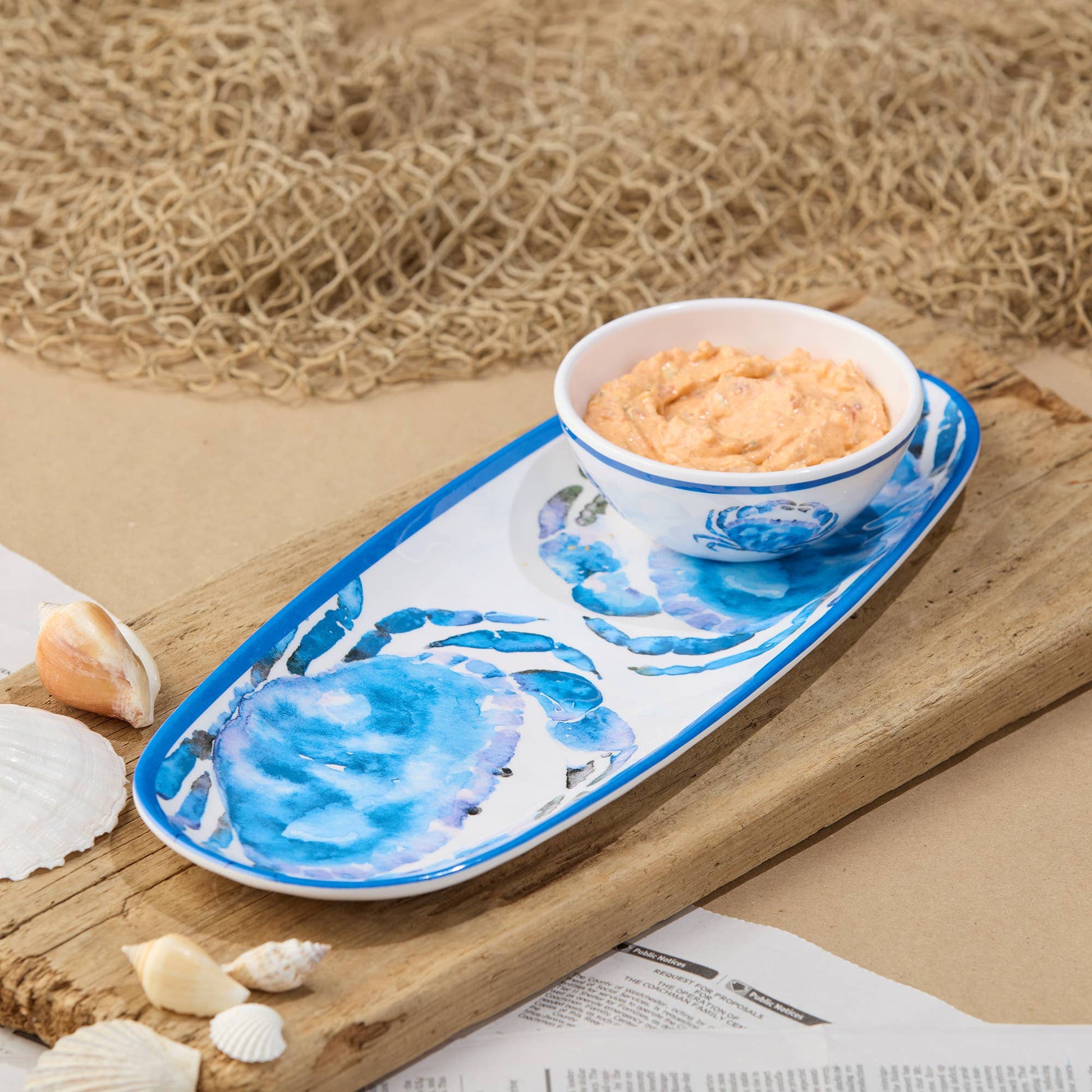 Decorative serving tray and bowl with blue crab design on a wooden surface