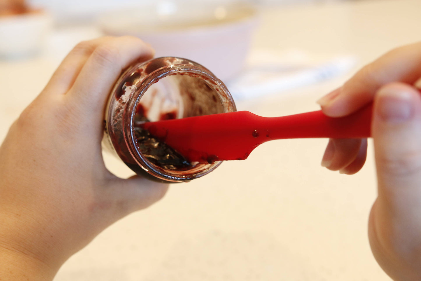 Person using a Butterie silicone spatula to scoop jelly from a jar