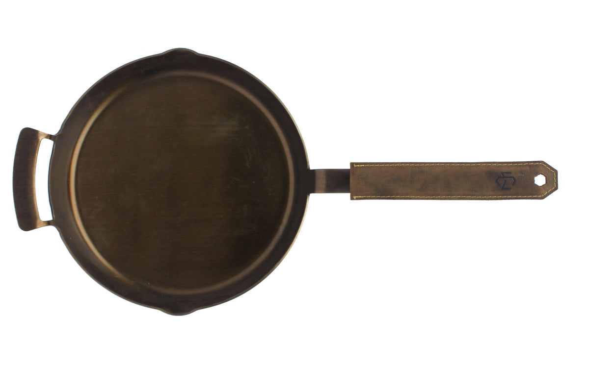 Black cast iron skillet with a handle on a white background