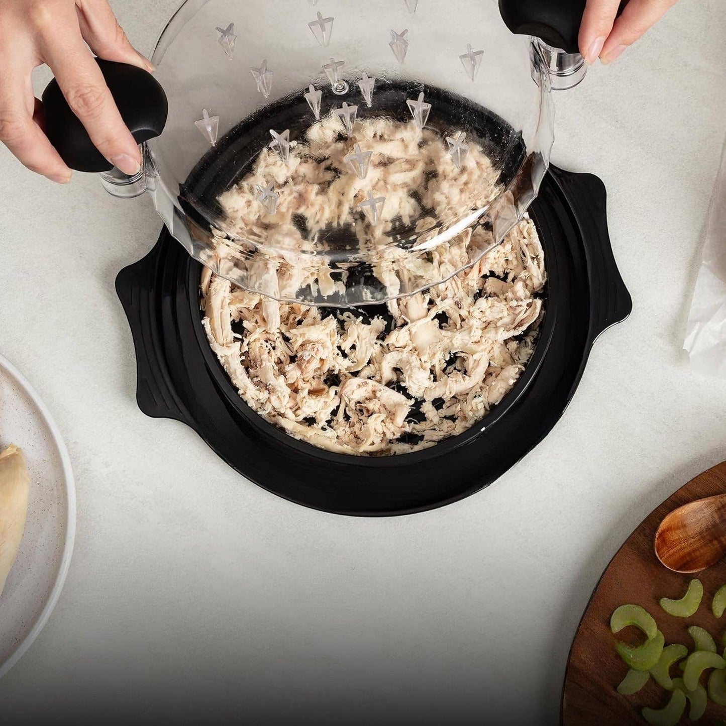Person using the chicken shredder tool to shred chicken