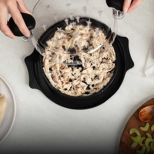 Person using the chicken shredder tool to shred chicken