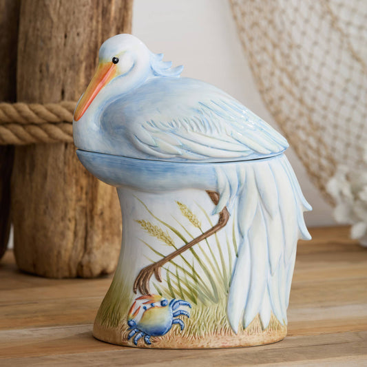 Decorative ceramic pelican cookie jar on a wooden surface with a natural background