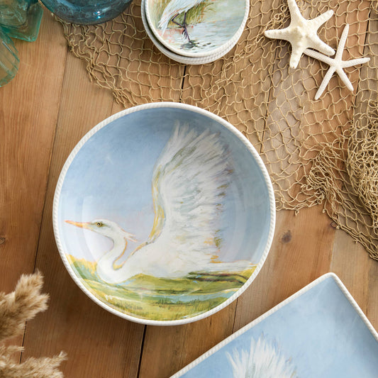 Decorative ceramic bowl with a painted scene of a bird on a wooden surface.