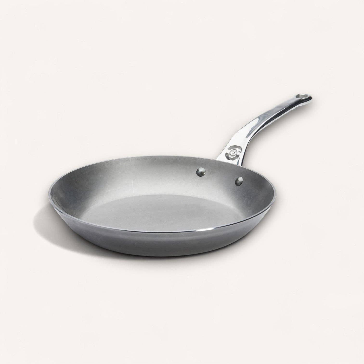 Cabon steel frying pan with a silver handle on a white background