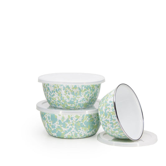 Set of three spatter-patterned bowls with lids on a white background