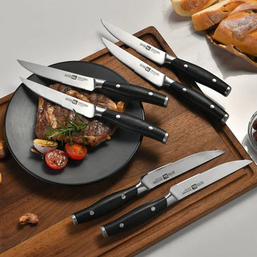 Set of Klaus Meyer Arcelor on a wooden cutting board with a plate of food