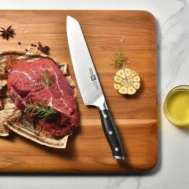 Raw steak with a Klaus Meyer Stahl Chef's  knife on a wooden cutting board, surrounded by herbs and spices.