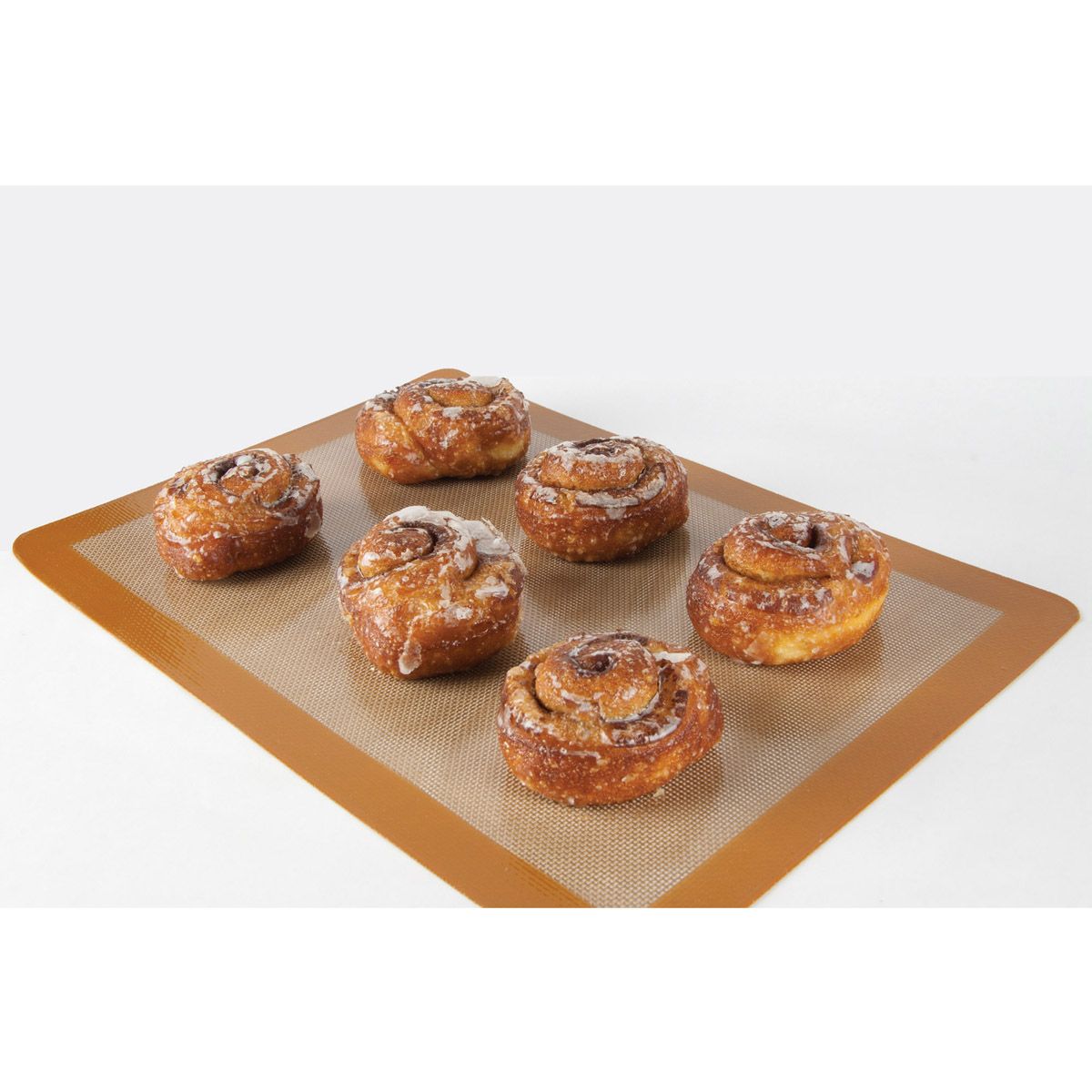 Cinnamon rolls on a silicone baking mat with a white background