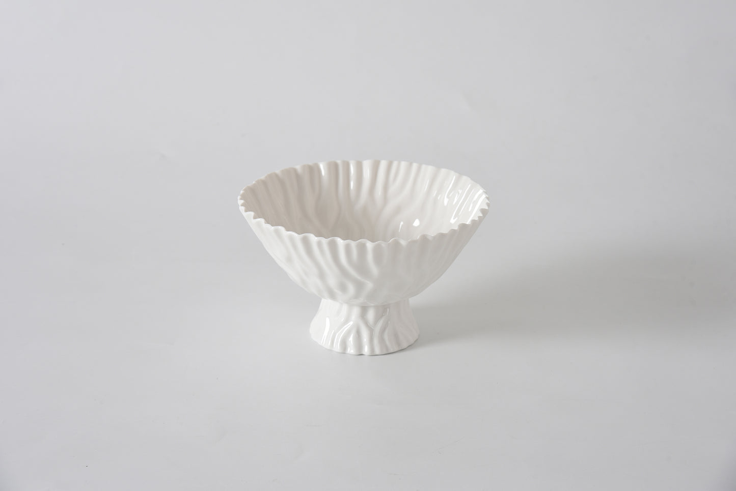 White ceramic bowl with textured design on a light gray background