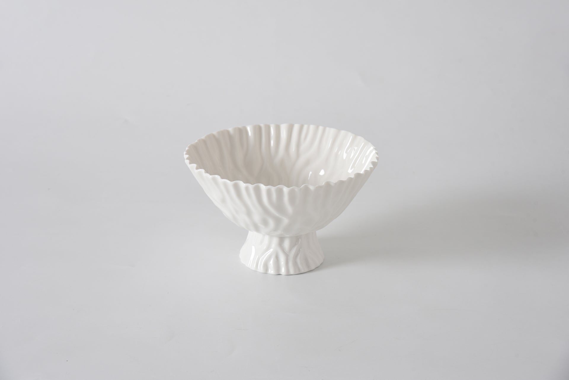 White ceramic bowl with textured design on a light gray background