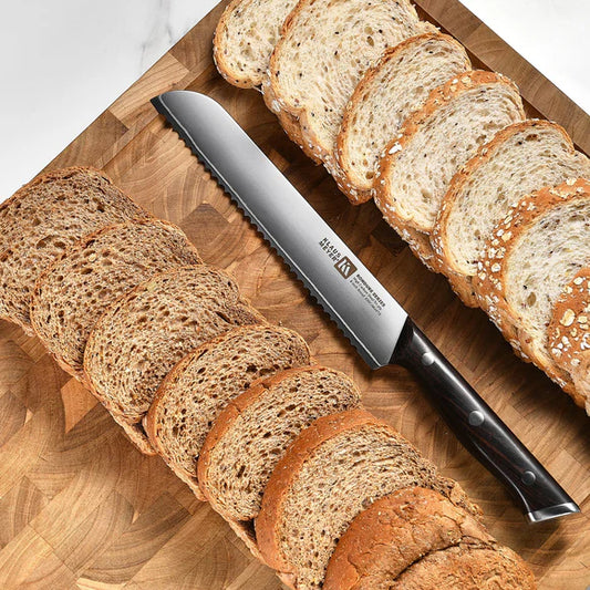 Sliced bread on a wooden cutting board with a Klaus Meyer Rondure bread knife.